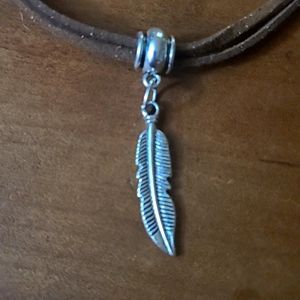 Handmade leather necklace with silver beads and a feather pendant